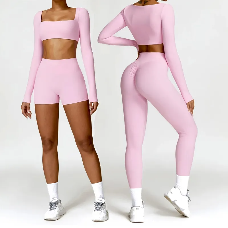 Two women modeling a light pink seamless activewear set—one in a crop top with shorts, the other in a matching crop top with high-waisted leggings.
