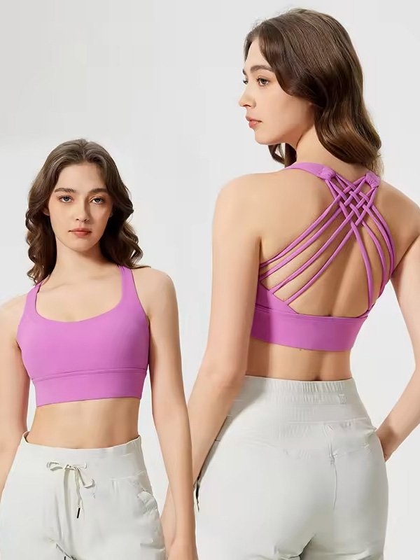 A woman wearing a purple sports bra with a crisscross back design, paired with white pants, showing both front and back views.