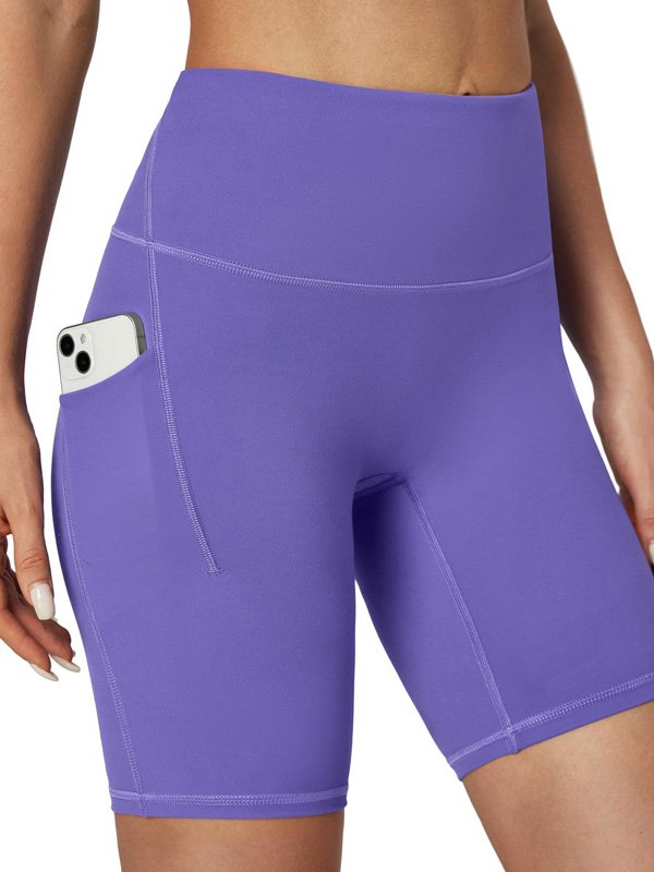 Woman wearing high-waisted purple athletic shorts with a phone pocket on the side, showcasing a smooth, stretchy fit and convenient design