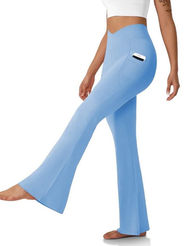 A pair of high-waisted flared yoga pants in light blue with a side pocket, worn by a model with a phone tucked in, highlighting comfort, style, and functionality