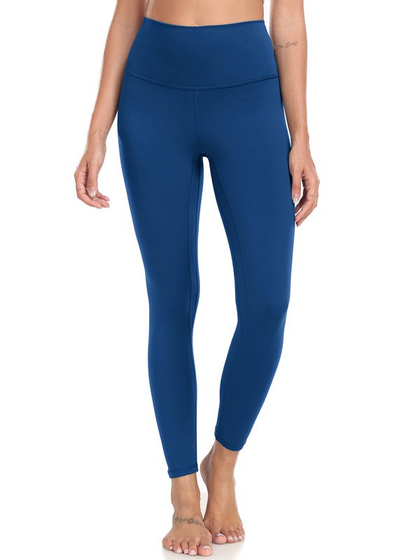 A pair of high-waisted custom yoga pants in blue, showcasing a sleek, fitted design, worn by a model with bare feet, emphasizing comfort and flexibility