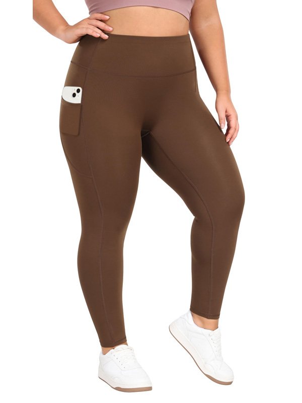 A pair of high-waisted yoga pants in brown, featuring a side pocket with a phone tucked in, worn by a model with white sneakers, highlighting comfort and functionality