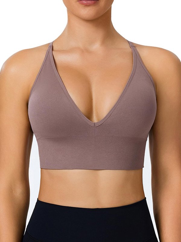 Woman wearing a deep V-neck, brown sports bra with a fitted design, showcasing a stylish and supportive look