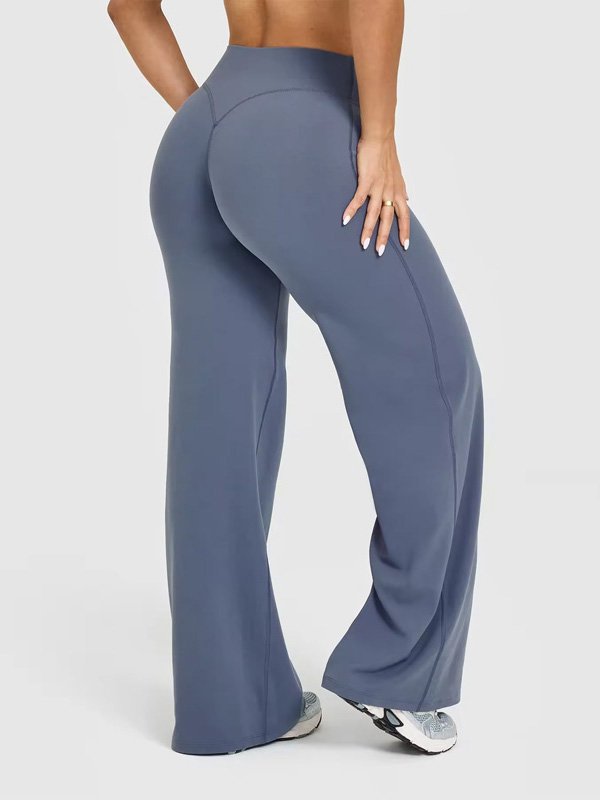 A pair of high-waisted, wide-leg yoga pants in blue, showcasing a smooth and flattering fit, worn by a model in sneakers, highlighting comfort, style, and flexibility