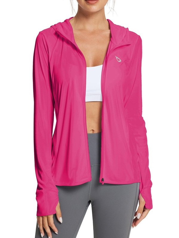 A woman wearing a bright pink zip-up hoodie with a hood, paired with a white sports bra and grey leggings, showcasing an energetic and sporty look