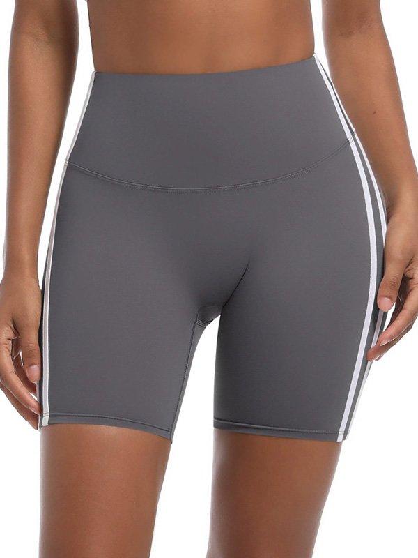 Woman wearing high-waisted gray athletic shorts with white side stripes, showcasing a sleek, fitted design and modern sporty style
