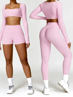 Two women modeling a light pink seamless activewear set—one in a crop top with shorts, the other in a matching crop top with high-waisted leggings.